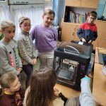 Uczniowie patrzą jak drukuje drukarka laserowa