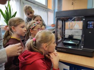 Dzieci obserwują wydruk 3D drukarki laserowej