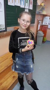 Uczennica z klasy 3b prezentuje serce z klocków lego.