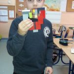 Uczeń z 3b prezentuje kolorowe serce z klocków lego.
