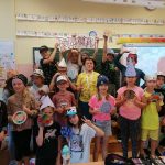 Uczniowie klasy 3 a ubrani w różne czapki w kropki prezentują kolorowe kropki.
